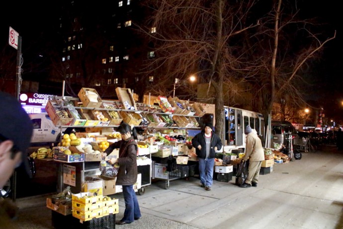 Buying vegetables at vegetable and fruit stand at East 116th Street near the corner of Second Avenue.