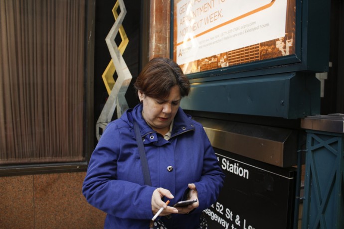 My wife, smoking a cigarette while checking messages on her iPhone.