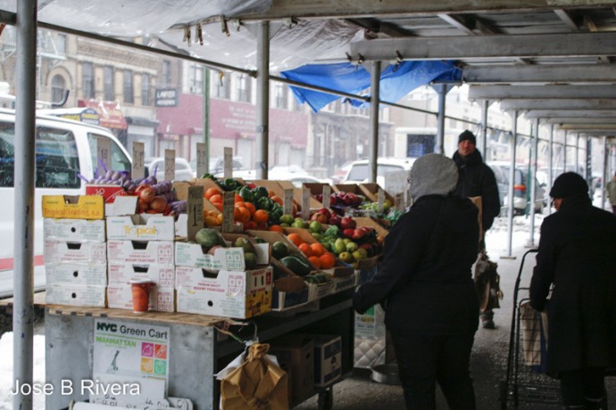 Fruit and Vegetable stand take cover underneath construction underpass during a blistery and snowy day.