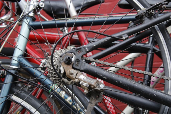 Close up of a few bicycles stacked next to each other.