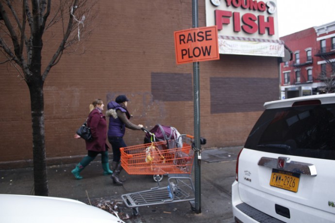 Two young ladies walk near two signs