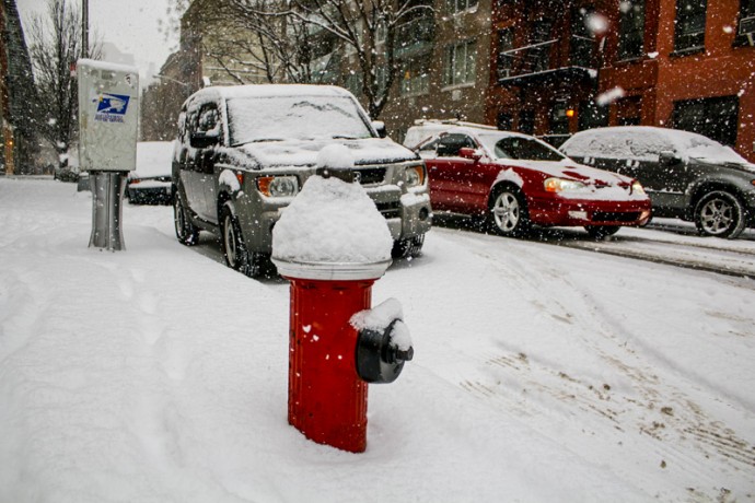 Red street hydrant covered in snow at East 111th Street between Second and Third Avenues.