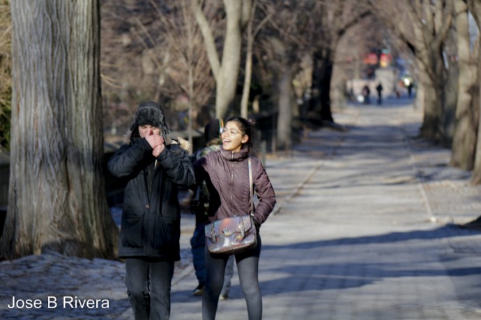 A couple walking on Fifth Avenue enjoying each other's company.