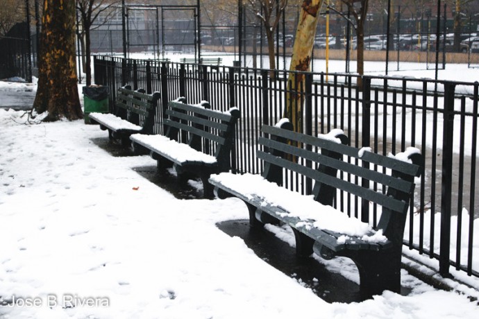 A snowy city park bench at East 109th Street and Third Avenue.