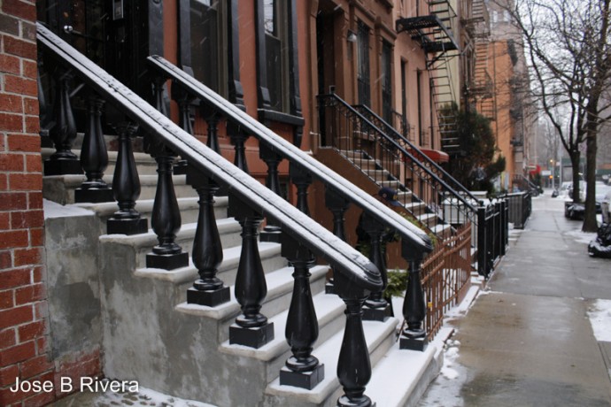Daytime photo of a snowy portion of East 107th Street between Lexington and Third Avenues.