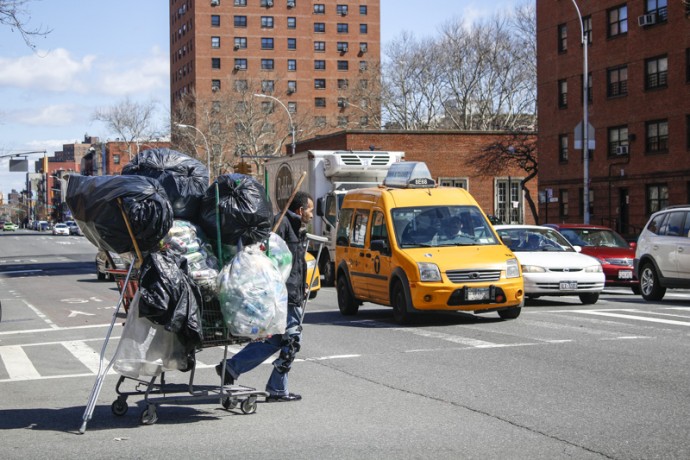 Can collector crossing the street on Second Avenue.