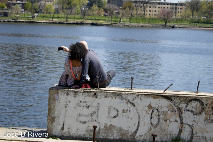 Two lovers sit by an abandoned and off limits cement pier near East 109th Street and the East River Esplanade.
