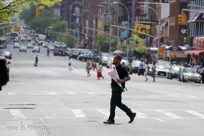 Young man with flowers for his lady. Taken on Third Avenue with a zoom lens which compressed all the other streets.