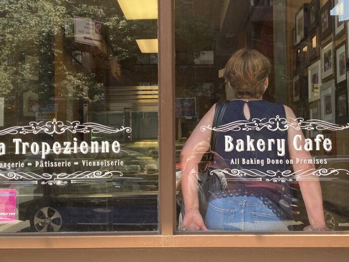 Our local French Bakery La Tropezienne. My wife is shown with her back to the inside of the glass.